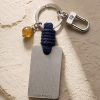 Porte-clé LIENFINITY avec citrine, corde bleue et plaque gravée sur fond beige texturé
