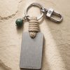 Porte-clé LIENFINITY – Jade néphrite verte – Corde sable Porte-clé LIENFINITY avec jade néphrite vert, corde sable et plaque gravée sur fond beige texturé