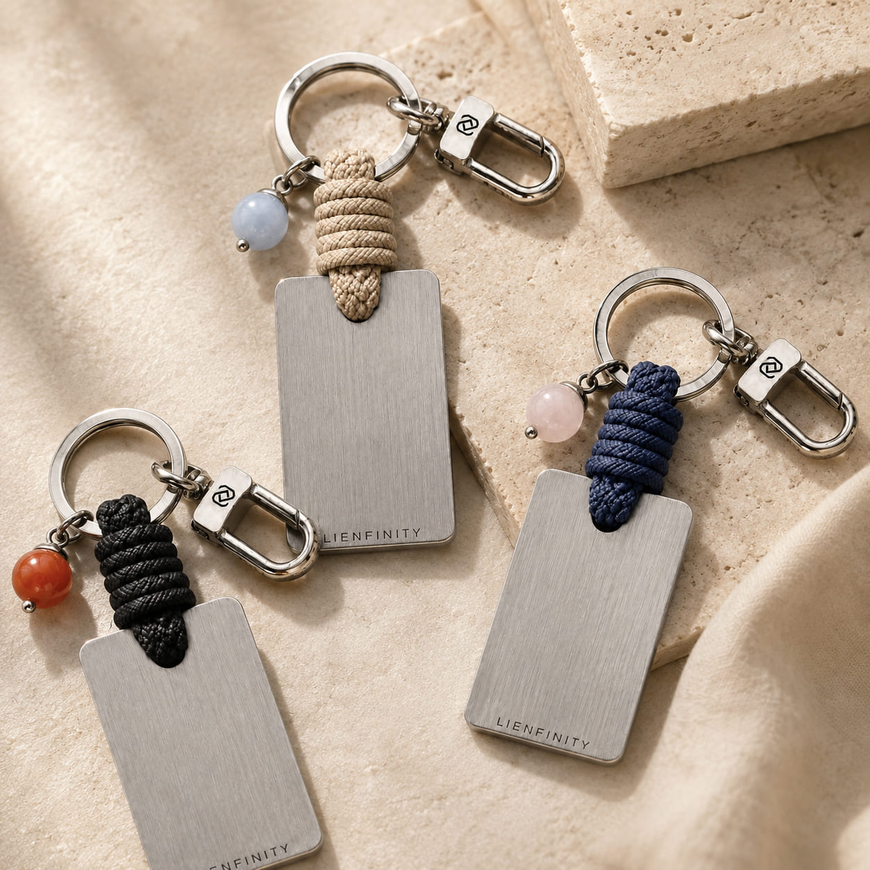 Trois porte-clés LIENFINITY en pierres naturelles avec cordons colorés et plaques gravées